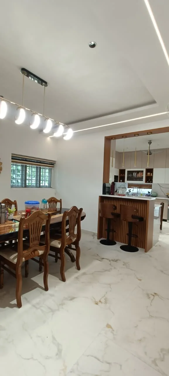 Home dining area with a timber partition, dining table and pendant lights