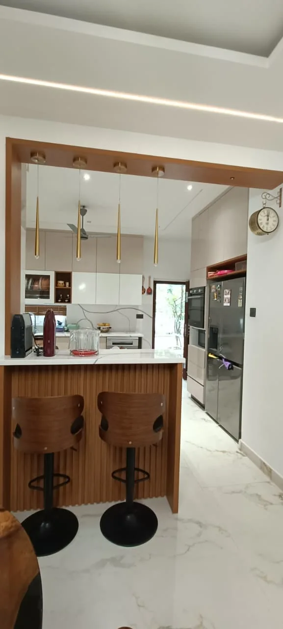 Kitchen breakfast counter with pendant lights, open storage and coordinated cabinetry