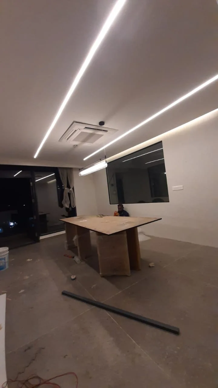 Office meeting area with ceiling-mounted air conditioning and linear light fixtures